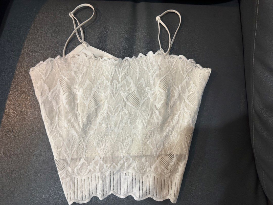 White lace cami crop top with straps (Category: Sleeveless) located in Manila. Submitted by decluterthings888 (Listing ID 1469427585, Image 1). Description: - Condition: Brand new with tags (BNWT) - Design: Delicate floral lace overlay on front and back - Details: Spaghetti straps and trendy scalloped hem - Material: Soft, stretchy fabric for a comfortable fit - Styling: Easy to pair with high-waisted jeans or skirts.
