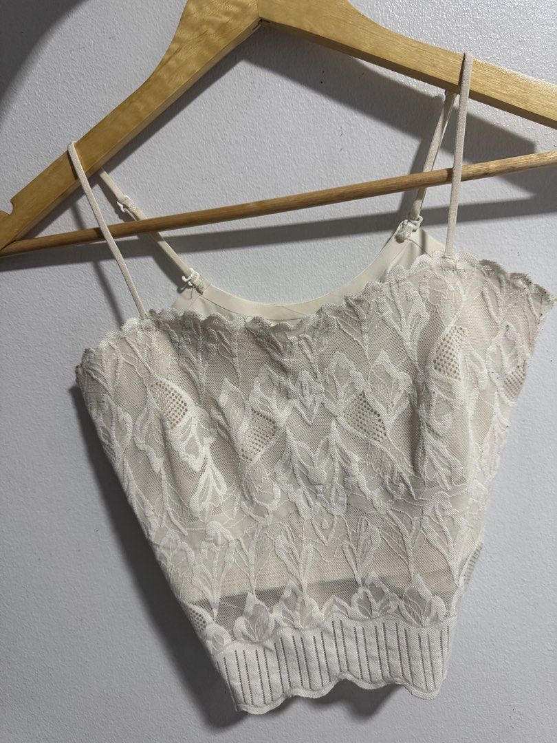 White lace cami crop top with adjustable straps (Category: Sleeveless) located in Manila. Submitted by decluterthings888 (Listing ID 1469427754, Image 2). Description: - Color: White - Material: Lightweight floral lace and mesh pattern - Straps: Thin and adjustable - Design: Scalloped hem details at top and bottom with a ribbed knit band - Style: Versatile crop top, ideal for warm-weather layering.