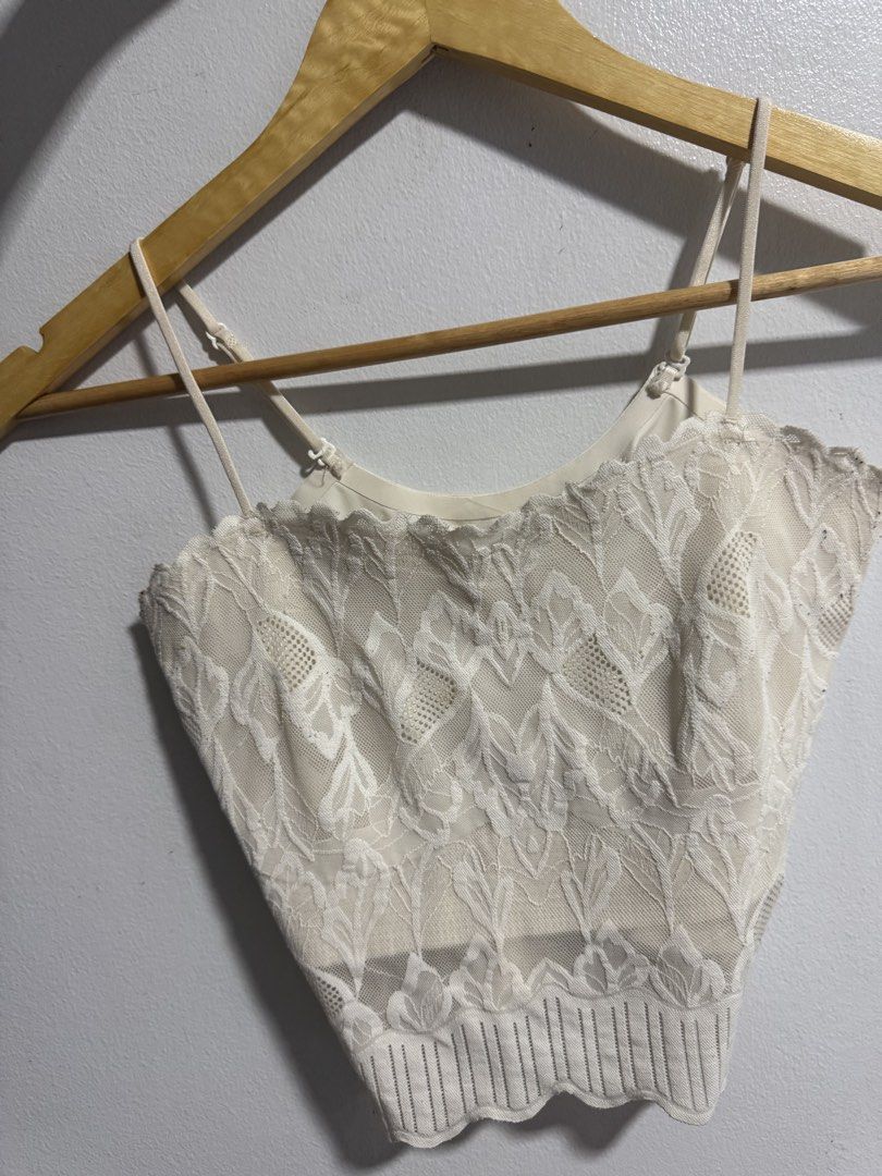 White lace cami crop top with adjustable straps (Category: Sleeveless) located in Manila. Submitted by decluterthings888 (Listing ID 1469427754, Image 1). Description: - Color: White - Material: Lightweight floral lace and mesh pattern - Straps: Thin and adjustable - Design: Scalloped hem details at top and bottom with a ribbed knit band - Style: Versatile crop top, ideal for warm-weather layering.
