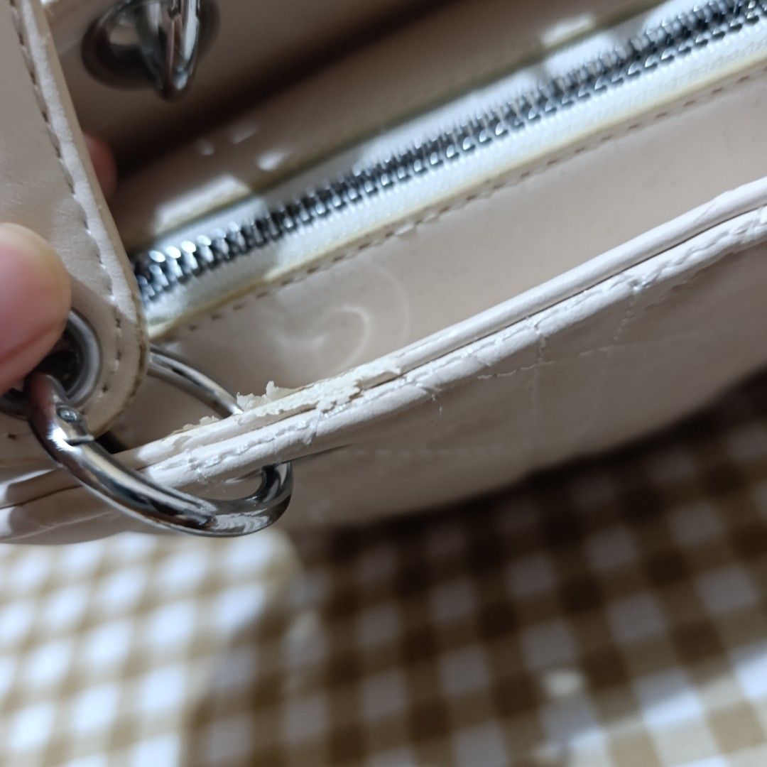 White Quilted Handbag with Silver Hardware and Strap (Category: Luxury Bags & Wallets) located in Las Pinas. Submitted by min_yanna (Listing ID 1469504383, Image 3). Description: - Color: Classic white with elegant silver hardware - Design: Chic quilted pattern with silver hanging letter charms - Versatility: Includes top handles and a detachable shoulder strap - Closure: Secure top zip closure - Condition: Shows general wear, with some peeling a