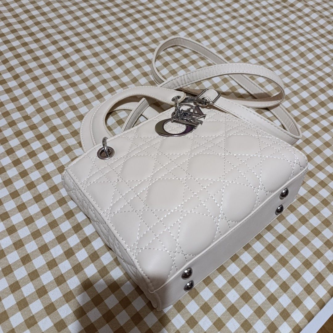 White Quilted Handbag with Silver Hardware and Strap (Category: Luxury Bags & Wallets) located in Las Pinas. Submitted by min_yanna (Listing ID 1469504383, Image 2). Description: - Color: Classic white with elegant silver hardware - Design: Chic quilted pattern with silver hanging letter charms - Versatility: Includes top handles and a detachable shoulder strap - Closure: Secure top zip closure - Condition: Shows general wear, with some peeling a