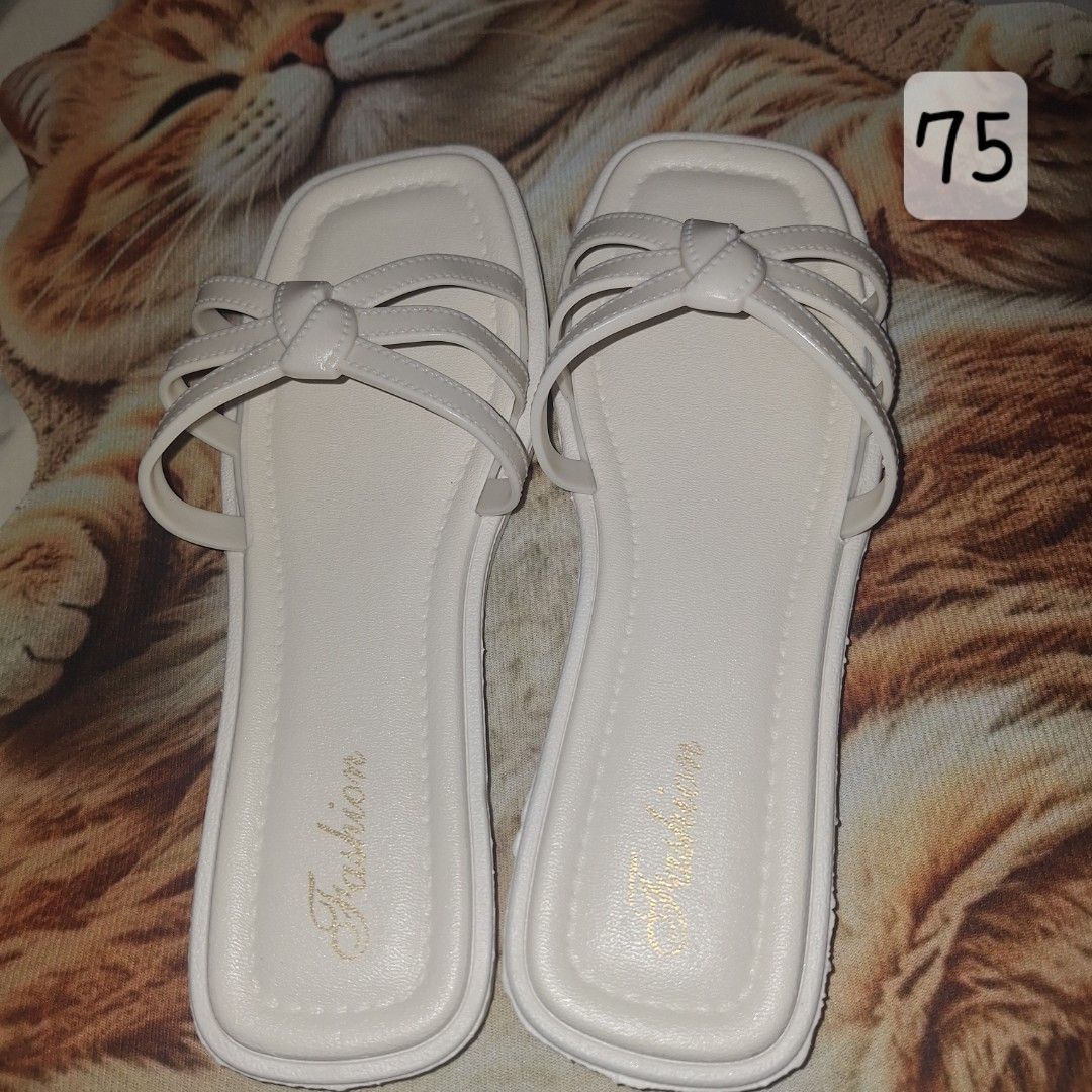 White Square Toe Flat Sandals with Knotted Straps (Category: Flats & Sandals) located in Manila. Submitted by noblegem04 (Listing ID 1469564152, Image 1). Description: - Color: Clean white - Style: Simple slip-on flat sandals - Design: Multiple thin straps with a cute center knot - Toe Shape: Trendy square toe - Insole: Features 'Fashion' gold foil lettering - Outsole: Textured grip for anti-slip walking - Condition: Brand new, perfect for everyd