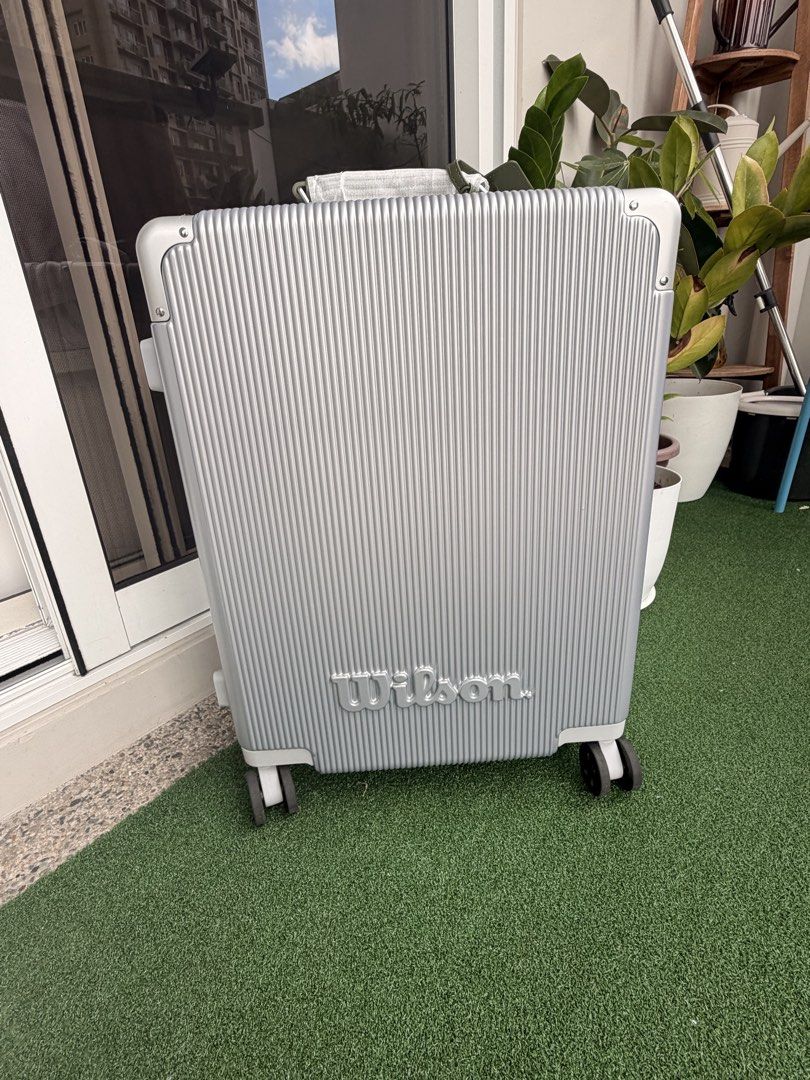 Wilson Silver Hardside Suitcase Luggage (Category: Luggage) located in Quezon City. Submitted by PrelovedbyPolene (Listing ID 1469409418, Image 2). Description: - Brand: Wilson Limited Edition - Color: Silver with vertical ribbed texture - Wheels: Smooth spinner wheels for easy mobility - Security: TSA-approved combination lock and secure metal clasps - Durability: Sturdy hardside frame with extra corner guards - Extras: Handle wrapped in protect