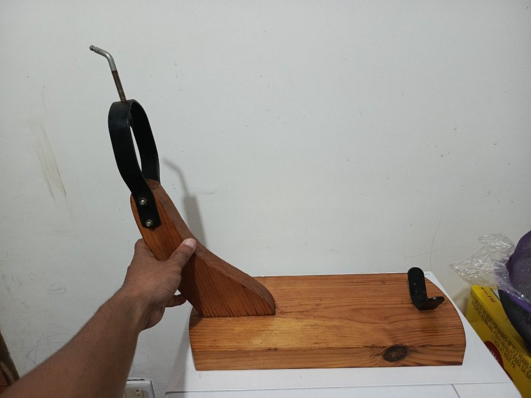 Wooden Ham Holder Stand Jamon Holder (Category: Shelves, Cabinets & Racks) located in Irosin. Submitted by whanchore55263 (Listing ID 1469414562, Image 3). Description: - Solid wooden base with a natural wood grain finish - Curved support arm and durable metal hardware - Top black metal ring with a threaded rod for stability - Base equipped with a metal bracket and spike to securely hold the ham - Sturdy construction, ideal for holiday dinners an
