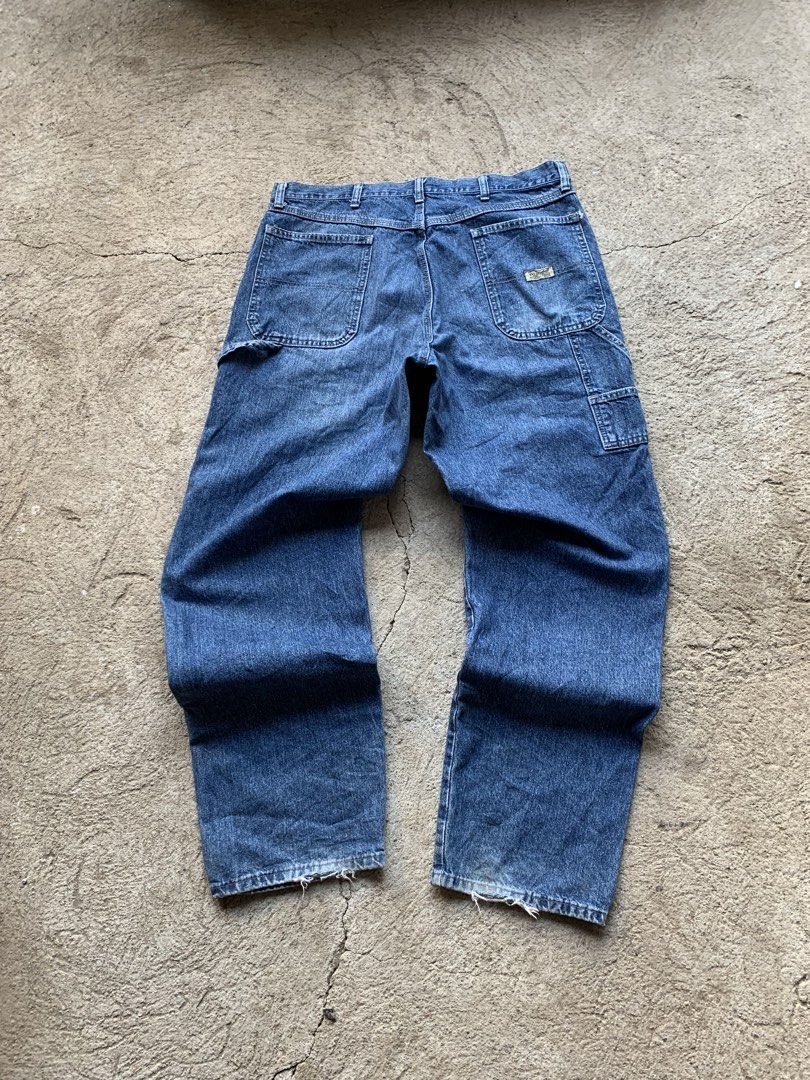 Wrangler Blue Denim Carpenter Jeans (Category: Jeans) located in Olongapo. Submitted by shokii (Listing ID 1469428905, Image 1). Description: - Brand: Wrangler - Style: Classic blue denim carpenter jeans with a relaxed fit - Features: Utility hammer loop, side tool pockets, and logo tag on back pocket - Details: Authentic distressed wear, faded wash, small knee tear, and frayed hems - Material: Heavy-duty 100% cotton denim - Condition: Great vint