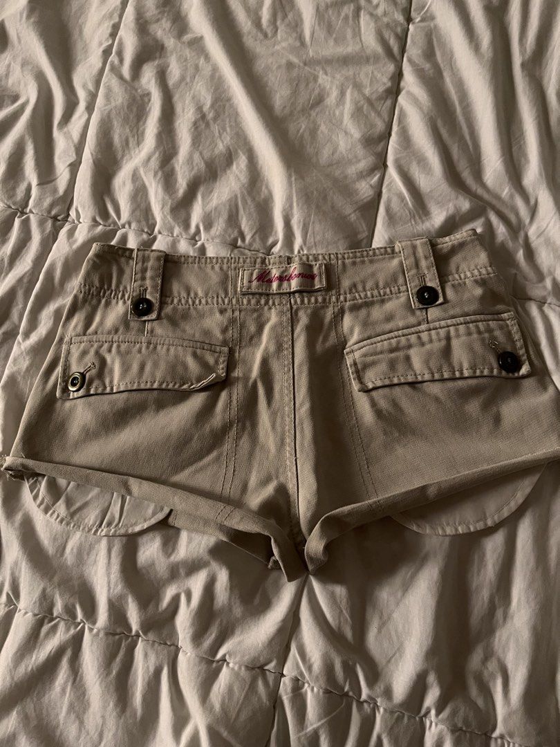 Y2K Low Rise Micro Shorts Vintage (Category: Shorts) located in Manila. Submitted by miyu.ga (Listing ID 1469473200, Image 2). Description: - Brand: Meters/bonwe - Color: Beige - Fit: Relaxed fit with a trendy cut-off curved hem - Closure: Double button waist with belt loops - Pockets: Multiple front pockets with dark brown buttons and cargo details on the back - Details: Sturdy fabric construction with stylish contrast stitching.