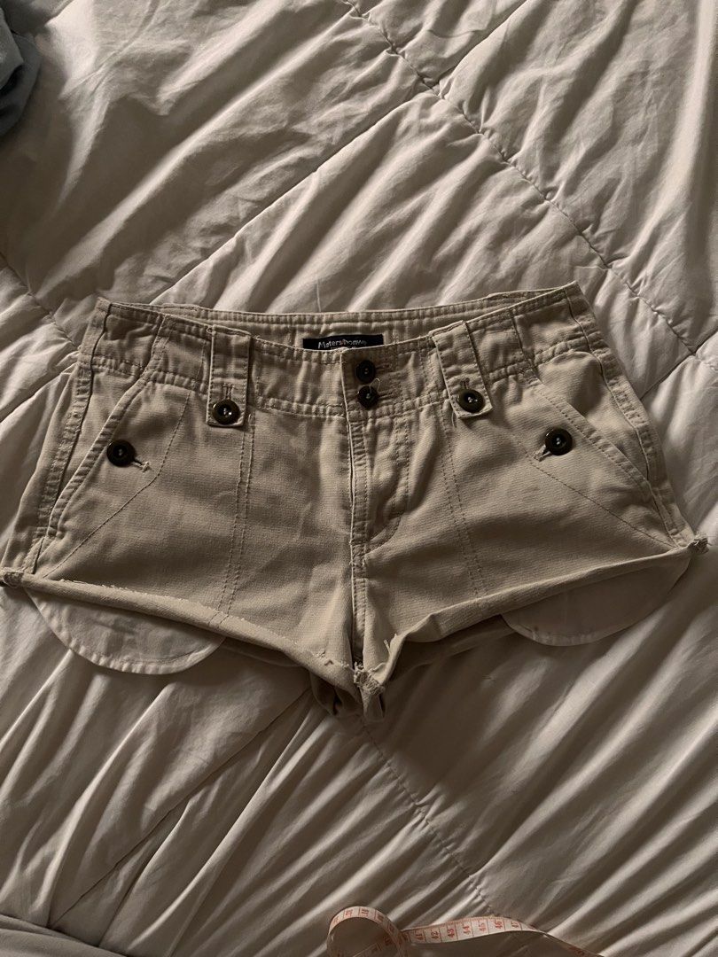 Y2K Low Rise Micro Shorts Vintage (Category: Shorts) located in Manila. Submitted by miyu.ga (Listing ID 1469473200, Image 1). Description: - Brand: Meters/bonwe - Color: Beige - Fit: Relaxed fit with a trendy cut-off curved hem - Closure: Double button waist with belt loops - Pockets: Multiple front pockets with dark brown buttons and cargo details on the back - Details: Sturdy fabric construction with stylish contrast stitching.