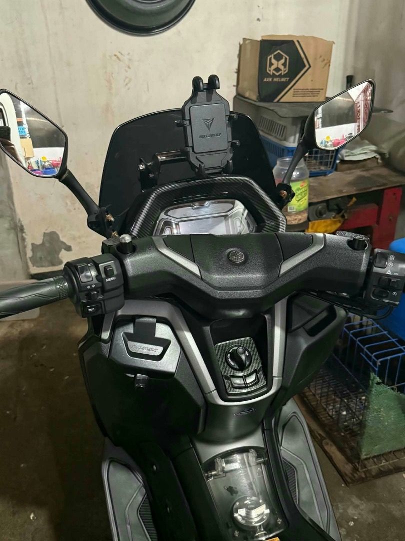 Yamaha NMAX v3 (Category: Motorbikes for Sale) located in Caloocan City. Submitted by amaracham (Listing ID 1469404273, Image 3). Description: Black Yamaha scooter. Tinted windshield installed. Side mirrors attached, carbon fiber pattern finish. Phone mount on the handlebar area. Odometer shows 13,688 kilometers. Clean body, ready to ride..