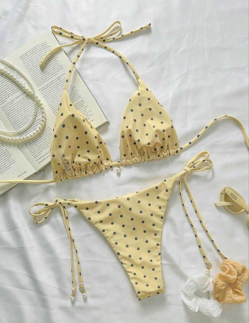 Yellow Polka Dot Bikini Pearl Charm Halter (Category: Bikinis & Swimsuits) located in Pasig City. Submitted by closetcleanoutmnl (Listing ID 1469512550, Image 2). Description: Yellow bikini set with dark polka dots all over. Halter neck top with adjustable triangle cups. Matching tie-side bottoms with adjustable coverage. Small faux pearl charm hanging between the top cups. Cute, playful style for sunny beach days or pool lounging. Unworn conditi