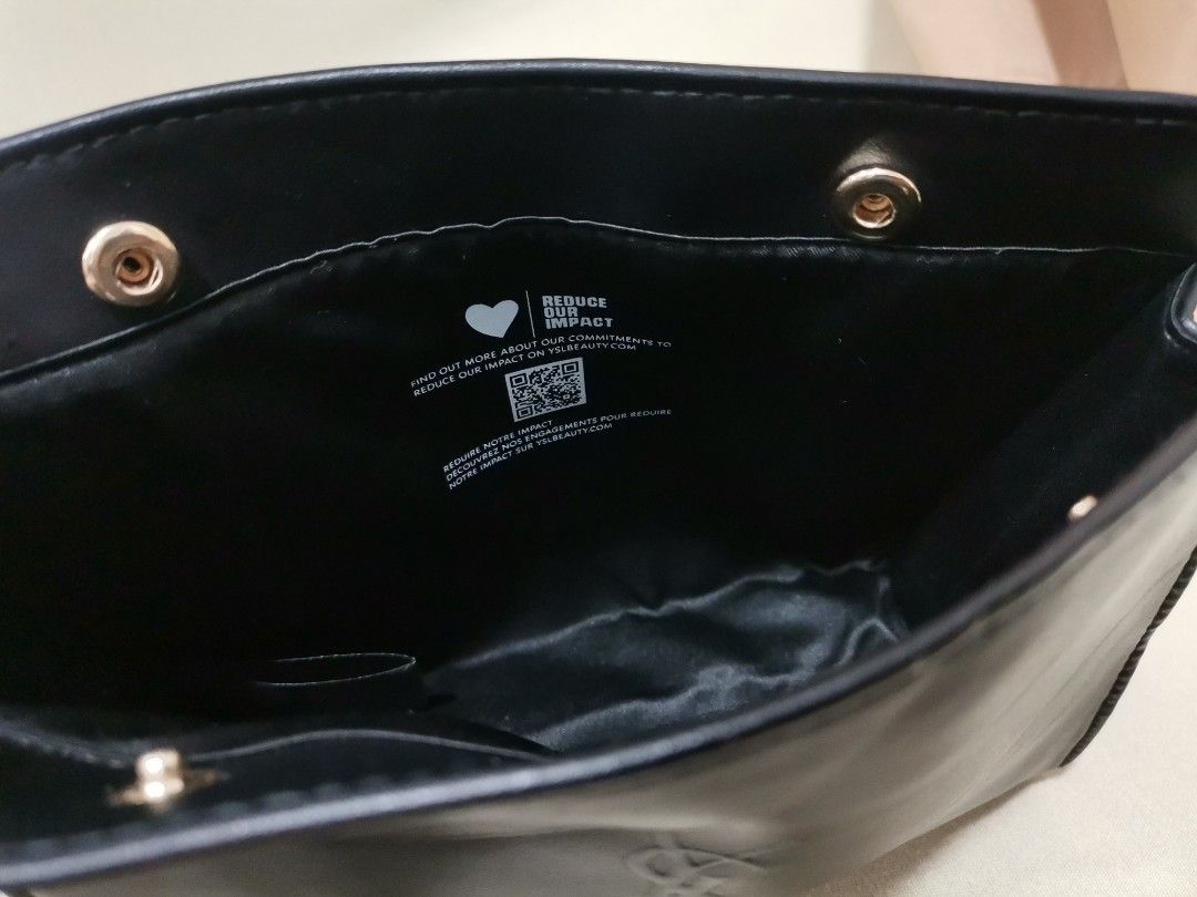 YSL Beauté flap pouch (Category: Luxury Bags & Wallets) located in Iba. Submitted by selector_items (Listing ID 1469544661, Image 3). Description: newest version - This is the *YSL Beauté flap pouch / clutch - the "Reduce Our Impact" edition* from 2023-2024 onwards: - *Front:* Flat envelope style with embossed *YSL + BEAUTÉ* logo, matte faux-leather (not the shiny vinyl of the older ones) - *Closure:* Two gold-tone snap buttons on the flap - you 