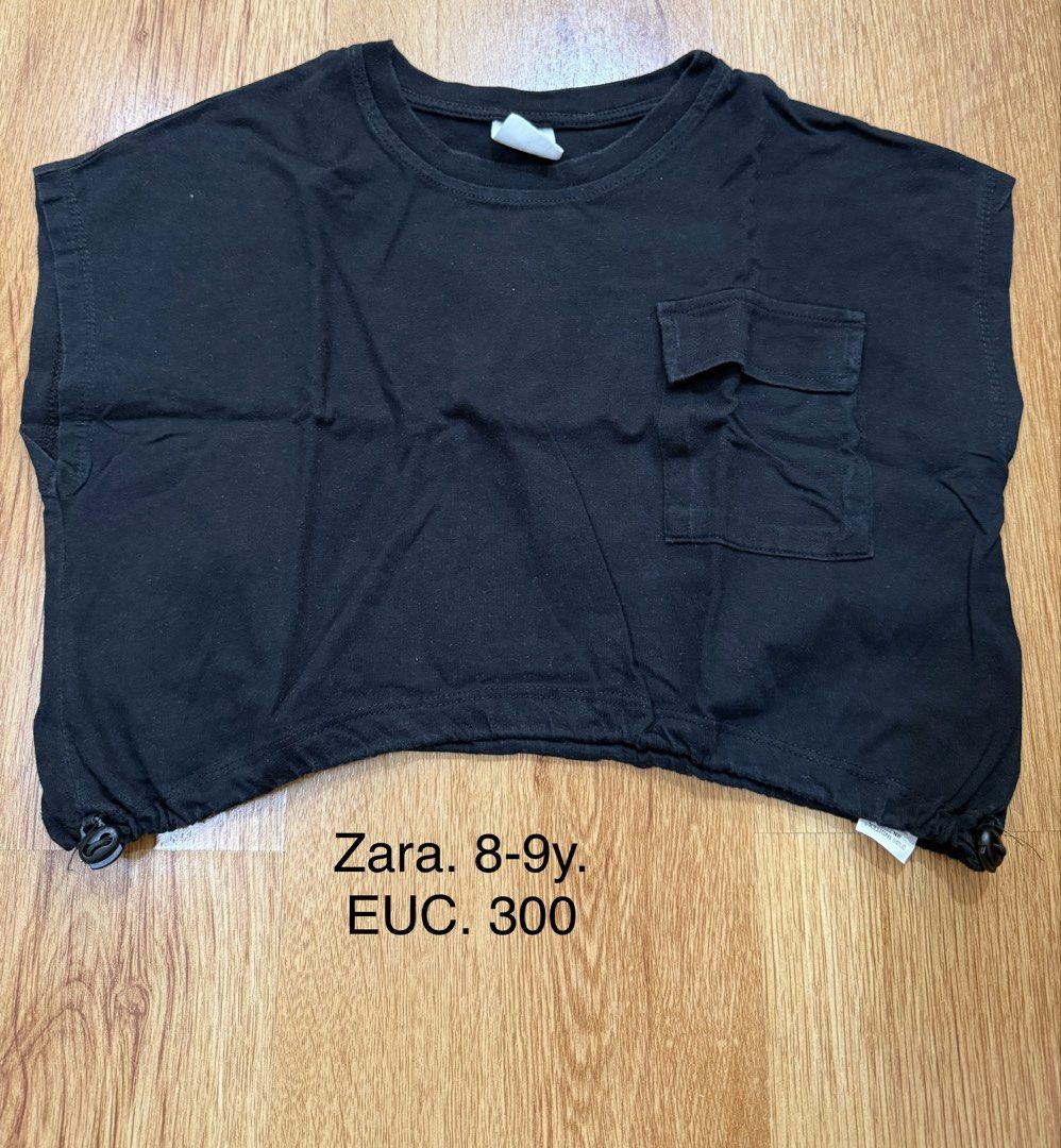 Zara Black Crop Top 8-9y (Category: Babies & Kids Fashion) located in Manila. Submitted by little_dees_shop (Listing ID 1469495389, Image 1). Description: - Brand: Zara - Color: Classic black - Size: Fits kids 8-9 years old - Design: Round neckline, short sleeves, and a front chest pocket with a flap - Feature: Adjustable drawstring with toggles on both sides of the bottom hem for a custom fit - Style: Simple and versatile everyday piece.