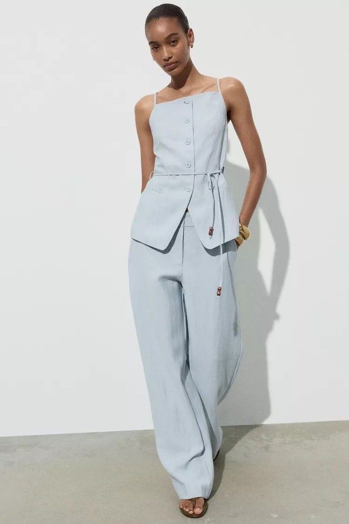 Zara Light Blue Button-Front Vest Top (Category: Sleeveless) located in Cavite. Submitted by momomochii (Listing ID 1469544190, Image 1). Description: - Brand: Zara - Color: Light blue - Size: EUR/USA XS - Design: Straight square neckline, thin straps, button-front closure, and tailored seams - Extra detail: Matching waist tie with beaded ends - Condition: likely new, no flaw.