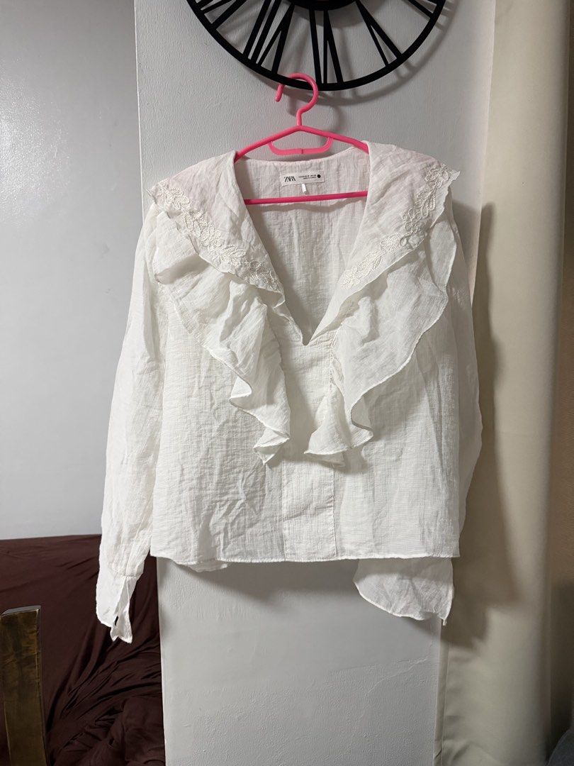 Zara White Embroidered Ruffle Blouse (Category: Blouses) located in Mandaluyong City. Submitted by blzstr (Listing ID 1469433581, Image 3). Description: Ruffled neckline with floral embroidery, V-neck, long sleeves with flared cuffs.