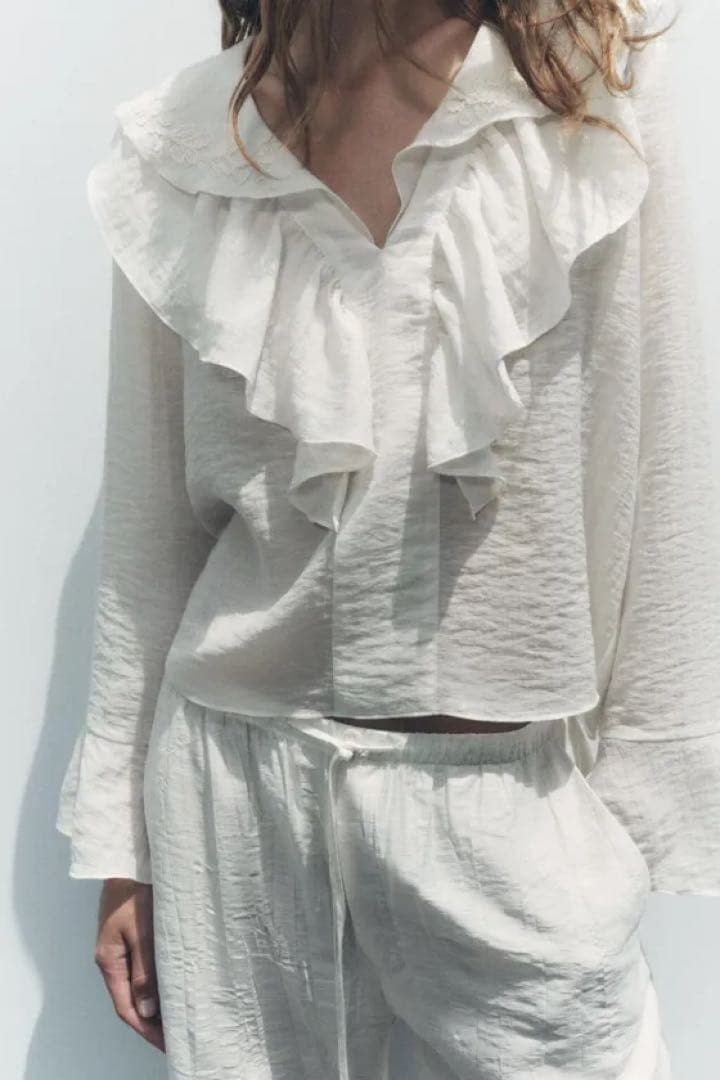 Zara White Embroidered Ruffle Blouse (Category: Blouses) located in Mandaluyong City. Submitted by blzstr (Listing ID 1469433581, Image 2). Description: Ruffled neckline with floral embroidery, V-neck, long sleeves with flared cuffs.