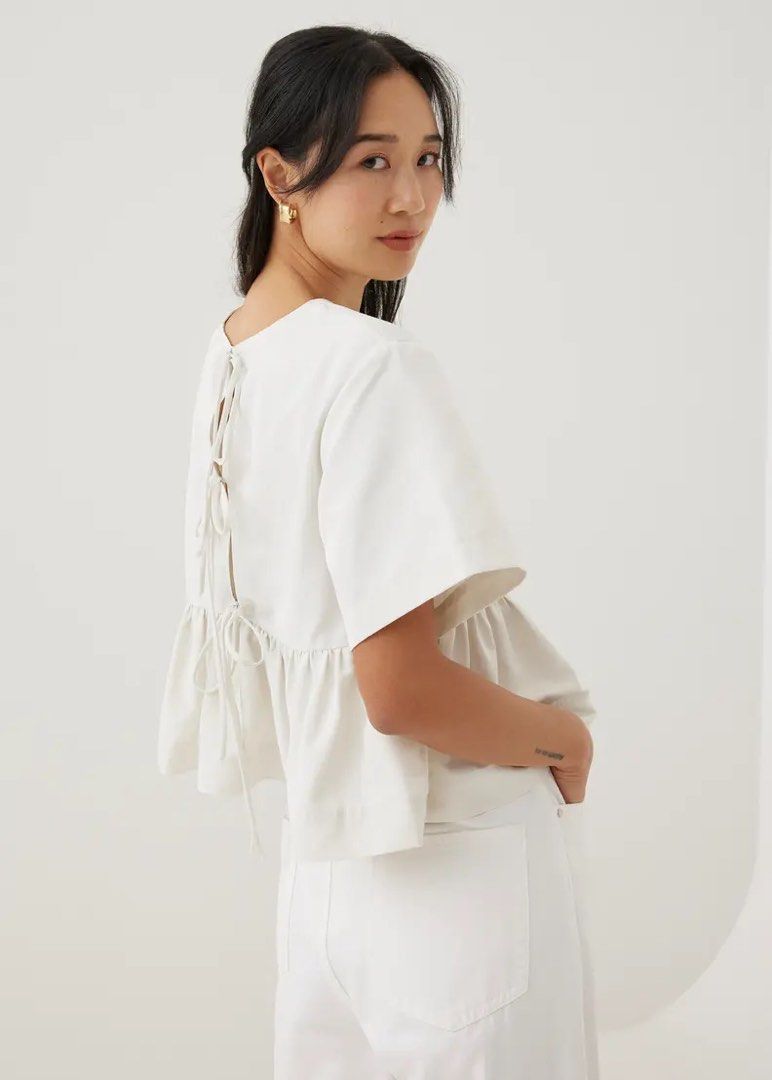 Zara White Tie-Back Peplum Blouse (Category: Blouses) located in Mandaluyong City. Submitted by blzstr (Listing ID 1469435832, Image 2). Description: PHOTOS FOR REFERENCE ONLY - Flowy babydoll short sleeve blouse with tiered ruffles - Cute ribbon tie-back closure at the upper back - Size: S (Made in Morocco) WITH STAIN ISSUE (not sure if washable, haven’t tried yet, nastock na).