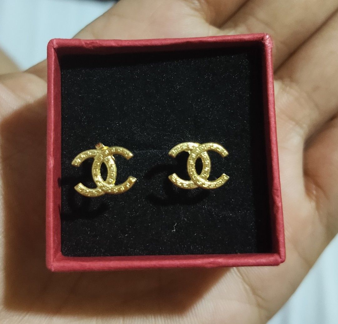 18k Saudi Gold CC Logo Stud Earrings (Category: Earrings) located in San Pablo. Submitted by leogirlshel (Listing ID 1469646660, Image 1). Description: - Iconic gold interlocking CC logo design - Textured finish for added elegance - Lightweight everyday wear (approx. 0.36 grams) - Post backs are fully intact - Includes the red storage box pictured.