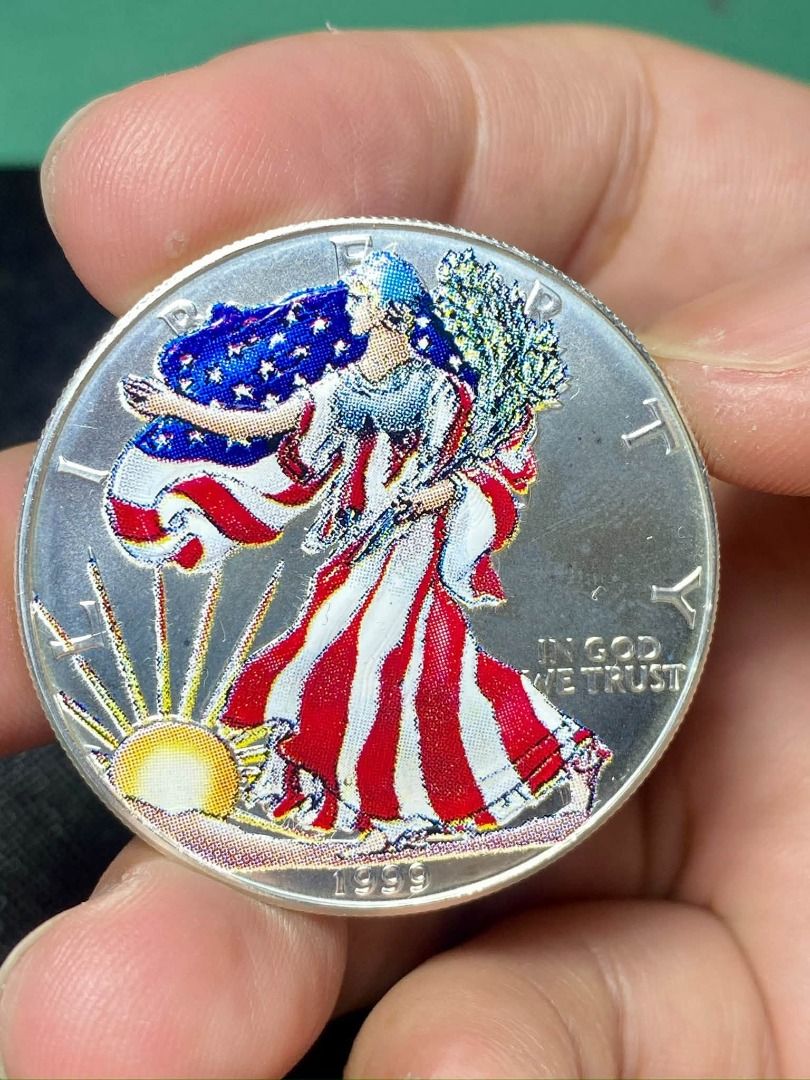 1999 Colorized American Silver Eagle 1oz Silver Coin (Category: Currency) located in Quezon City. Submitted by adonbilibit (Listing ID 1469608891, Image 2). Description: - 1999 American Silver Eagle collectible coin - Hand-painted color details showcasing Lady Liberty, the US flag, and oak branches - Features a vibrant sunrise design and 'IN GOD WE TRUST' stamp - Classic reeded edge texture along the silver rim - Note: Minor fingerprints visible 