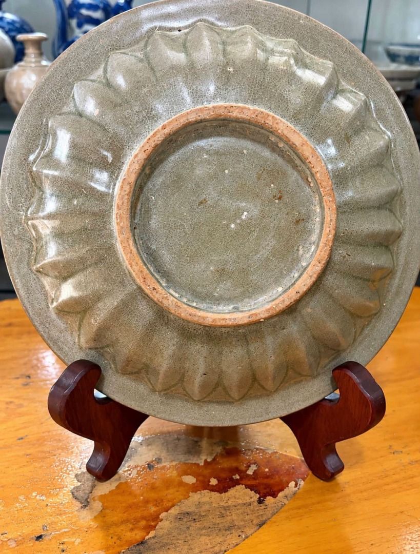 9 inchess Diameter , Longquan Celadon (Category: Vases & Decorative Bowls) located in Alfonso. Submitted by luckyfire_80773d (Listing ID 1469592662, Image 2). Description: - Authentic green celadon glazed bowl - Features two molded fish figures in the center - Beautiful ribbed chrysanthemum pattern carved on the exterior - Unglazed circular foot rim revealing the reddish-brown clay body - Includes a black wooden display stand with elegant gold-pa