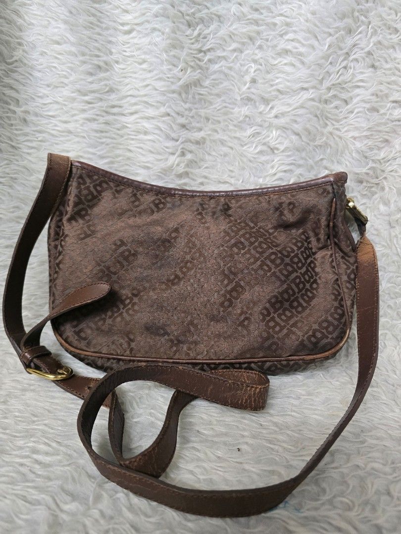 💯% AUTHENTIC Bally Vintage brown monogram shoulder bag (Category: Shoulder Bags) located in Marikina City. Submitted by dust.end.bags (Listing ID 1469610316, Image 1). Description: - Brown monogram shoulder bag with repeating letter pattern - Adjustable leather strap with surface cracking and wear - Secure zip closure main compartment - Classic gold-tone hardware buckle - Compact structured shape with visible fading on the fabric exterior.