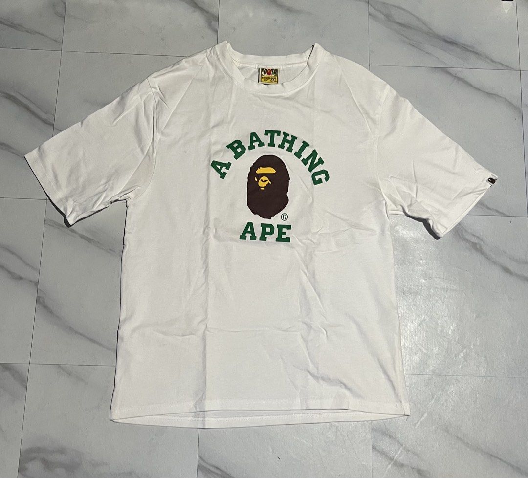 A Bathing Ape White Ape Logo T-Shirt (Category: Tshirts & Polo Shirts ) located in Cavite. Submitted by christianzuuu (Listing ID 1469740620, Image 1). Description: - Issues: 9/10 colorate need wash - Brand: Bape - Color: White with green and brown Ape head graphic - Size: Tagged 2XL (Actual measurements: 20" width x 27" length) - Material: 100% cotton, Made in Bangladesh - Condition: Includes original neck label and sleeve ape tag - Style: Class