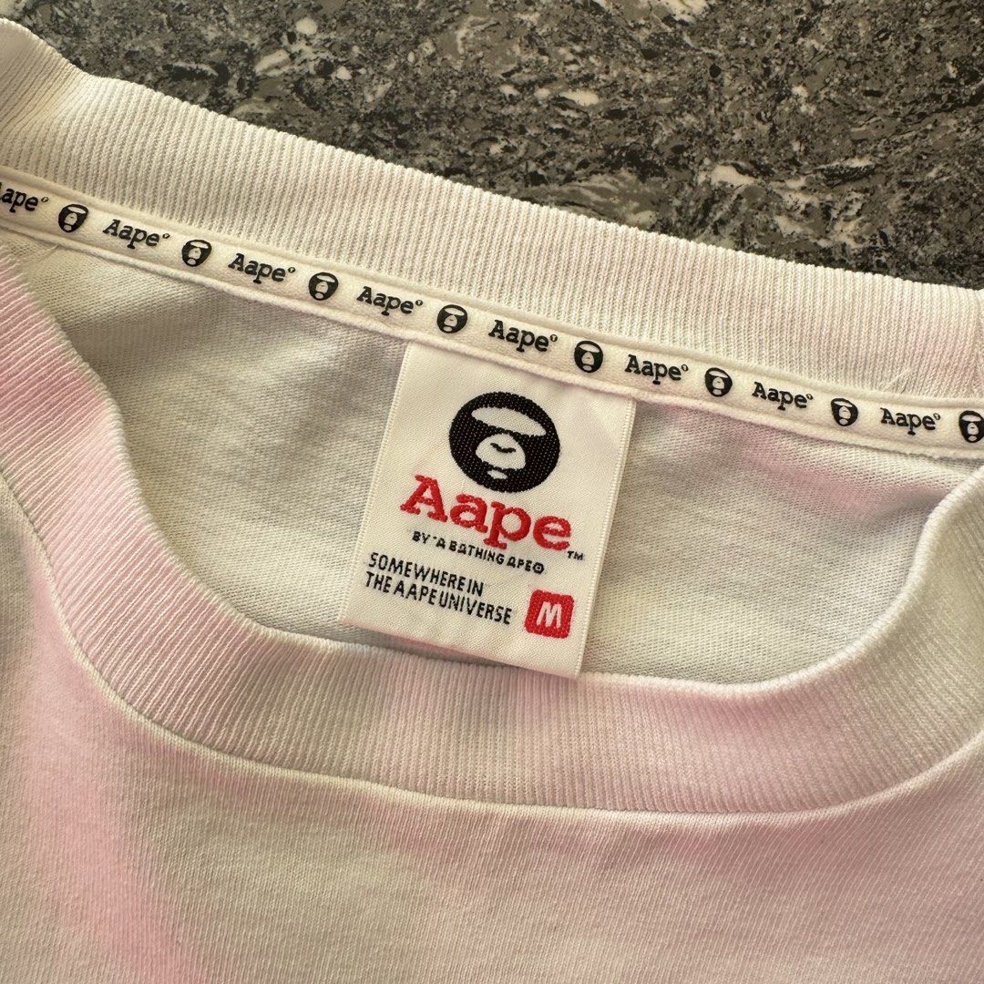 Aape by a bathing ape (Category: Formal Shirts) located in Bulacan. Submitted by b4mzz (Listing ID 1469638843, Image 3). Description: AAPE UNVS Tee 🦍 Clean white graphic tee featuring the signature AAPE UNVS design. Authentic piece with standout streetwear details. 📏 Width: 22” | Length: 28” 🎨 Color Rate: 10/10 ⚠️ Issue: Minimal pinhole 💬 Open for reasonable offers!.