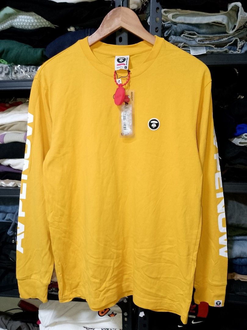 AAPE NOW Yellow Long Sleeve Tee (Category: Tshirts & Polo Shirts ) located in Manila. Submitted by mjthrifted_second (Listing ID 1469638798, Image 1). Description: - Brand: AAPE NOW - Item: Bright yellow long sleeve t-shirt - Size: Large (L) -Dimes: 20/27 - Condition: Brand new with tags attached, never worn - Details: Graphic text on sleeves and back collar, embroidered ape head logo on chest - Style: Clean, vibrant piece perfect for everyday st