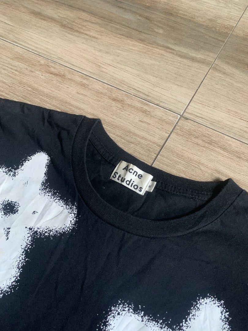Acne Studios Star Print Black Tee Size XL (Category: Luxury Apparel) located in Tarlac. Submitted by luxurious_apparel (Listing ID 1469660762, Image 2). Description: - Brand: Acne Studios (Stockholm) - Color: Black with white spray paint star graphic print - Size: XL - Fit: Standard fit, short sleeves - Material: 100% Cotton, Made in Portugal - Condition: Great piece from the iconic Stockholm fashion house.