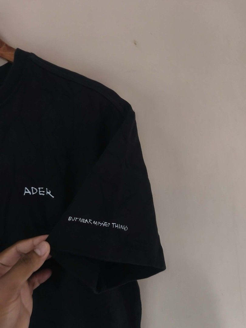 Ader Error Black Graphic T-Shirt (Category: Tshirts & Polo Shirts ) located in Manila. Submitted by cookthrift (Listing ID 1469576643, Image 3). Description: - Brand: Ader Error - Collection: 2020 Fall/Winter - Color: Black - Fit: Classic fit, comfortable 100% cotton - Details: Small chest embroidery, sleeve text 'BUT NEAR MISSED THINGS', and large back text print - Authenticity: Includes signature blue inner brand tag - Condition: Great streetwe