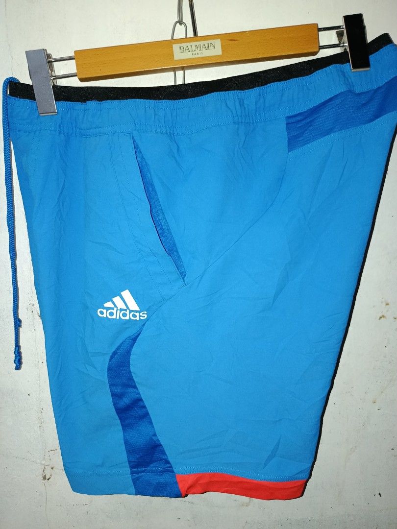 Adidas Blue Athletic Shorts with Drawstring (Category: Shorts) located in Nabunturan. Submitted by marmitoren42236 (Listing ID 1469624338, Image 1). Description: - Color: Bright blue with black and orange details - Material: Lightweight fabric, ideal for workouts or casual wear - Features: Black elastic waistband with blue drawstring, side pockets, and contrast side panels - Branding: White Adidas logo on the leg - Condition: Excellent, ready to 