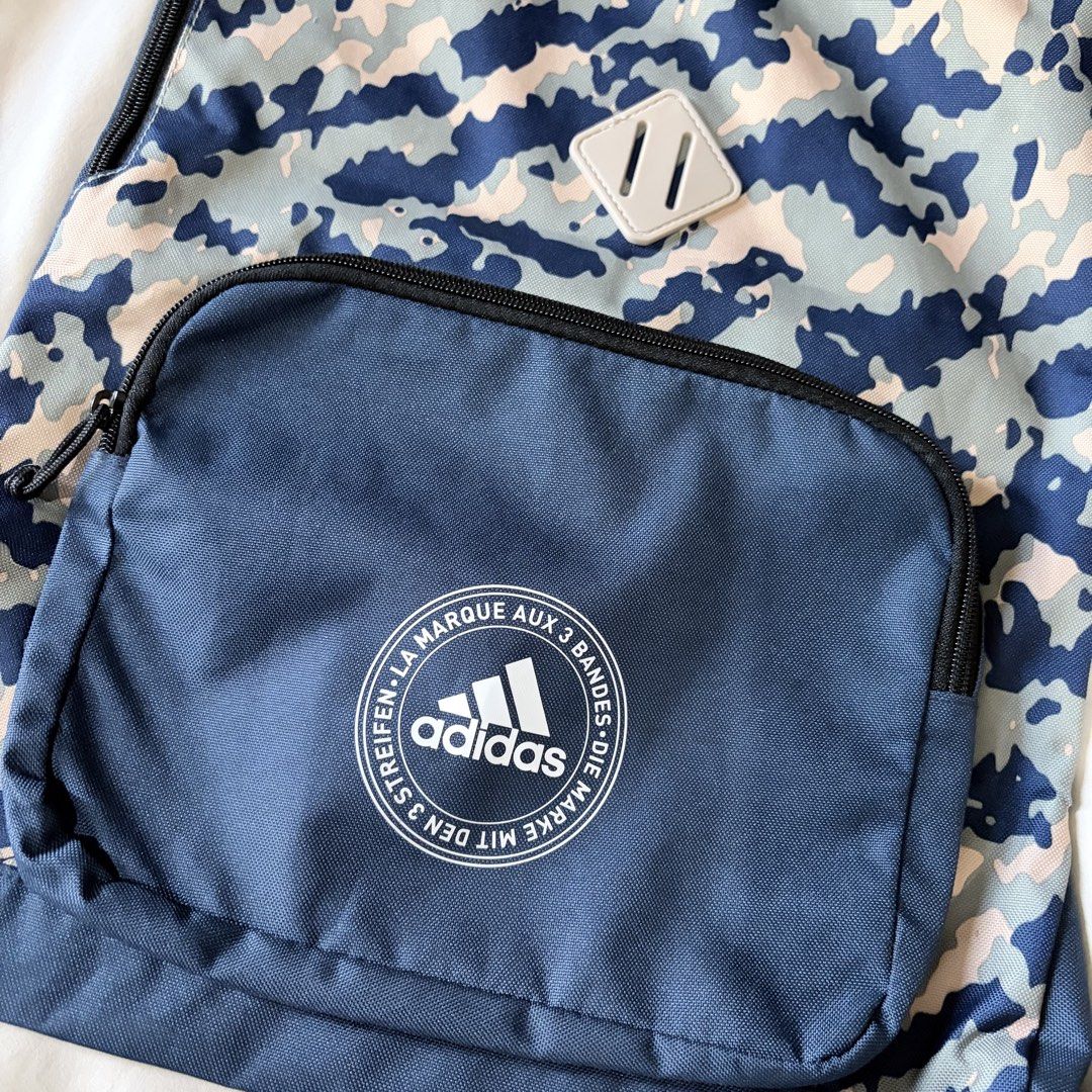 Adidas Camo Gym Sack Drawstring Bag Blue (Category: Backpacks) located in Quezon City. Submitted by angelajuliet__ (Listing ID 1469611533, Image 2). Description: - Brand: Adidas - Design: Blue camo pattern with classic circular logo print - Storage: Large main compartment with secure drawstring closure - Extra features: Front zippered pocket and grey diamond lash tab - Condition: Clean overall, perfect for the gym, school, or daily errands.