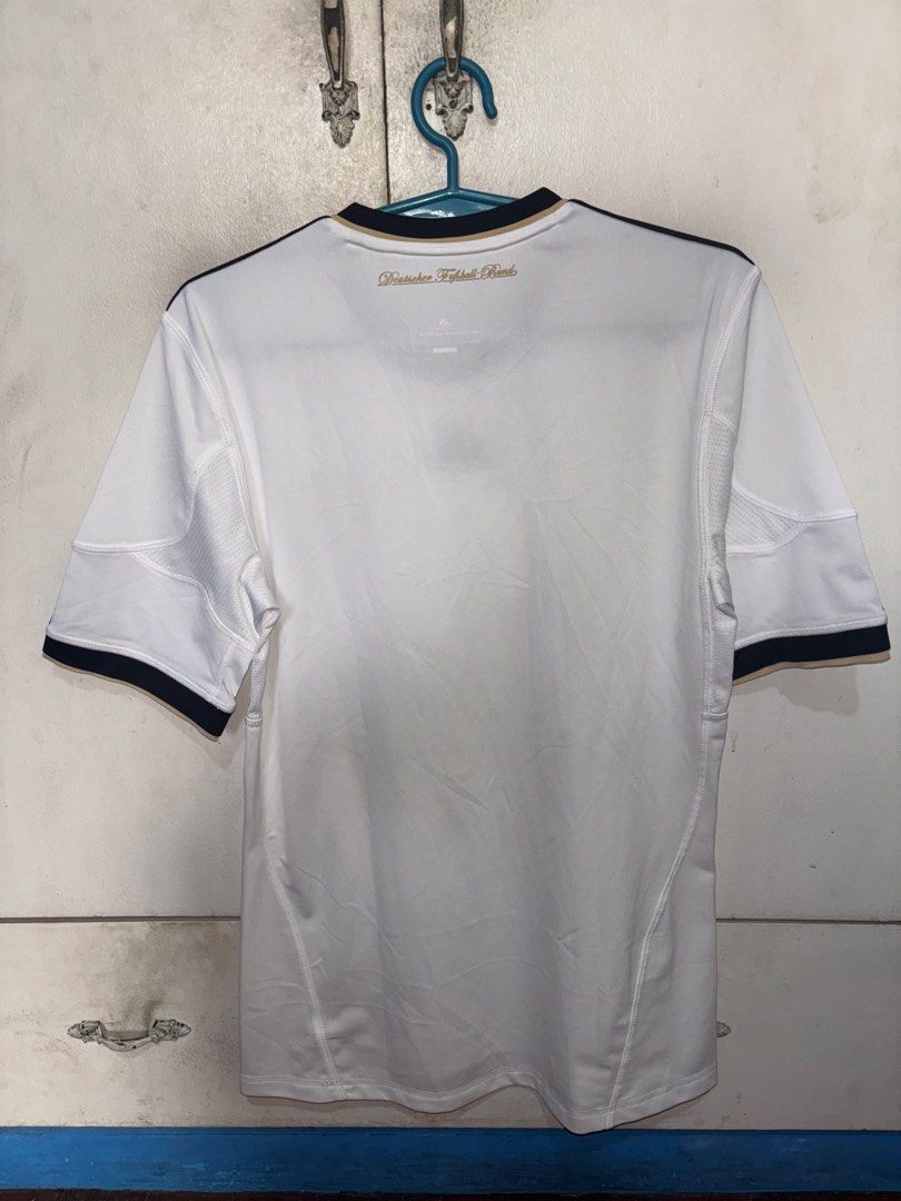 Adidas Germany 2010/2011 Home Kit (Category: Activewear) located in Pasig City. Submitted by timmybatoon (Listing ID 1469601379, Image 2). Description: - Classic white home jersey from Germany's iconic 2006 World Cup campaign - Features the striking black, red, and gold vertical stripe down the front - Embroidered Adidas logo and DFB crest with 3 championship stars - Deutscher Fußball-Bund lettering on the back collar - Climacool technology for b