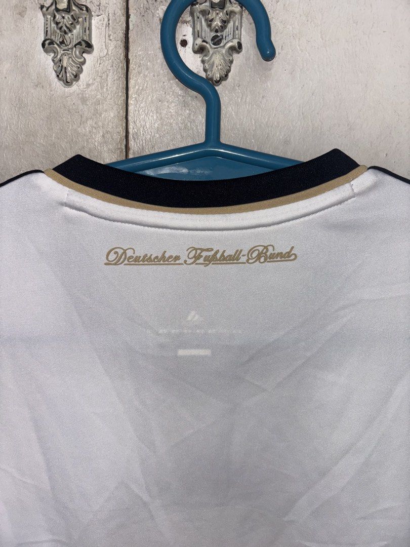 Adidas Germany 2010/2011 Home Kit (Category: Activewear) located in Pasig City. Submitted by timmybatoon (Listing ID 1469601379, Image 3). Description: - Classic white home jersey from Germany's iconic 2006 World Cup campaign - Features the striking black, red, and gold vertical stripe down the front - Embroidered Adidas logo and DFB crest with 3 championship stars - Deutscher Fußball-Bund lettering on the back collar - Climacool technology for b