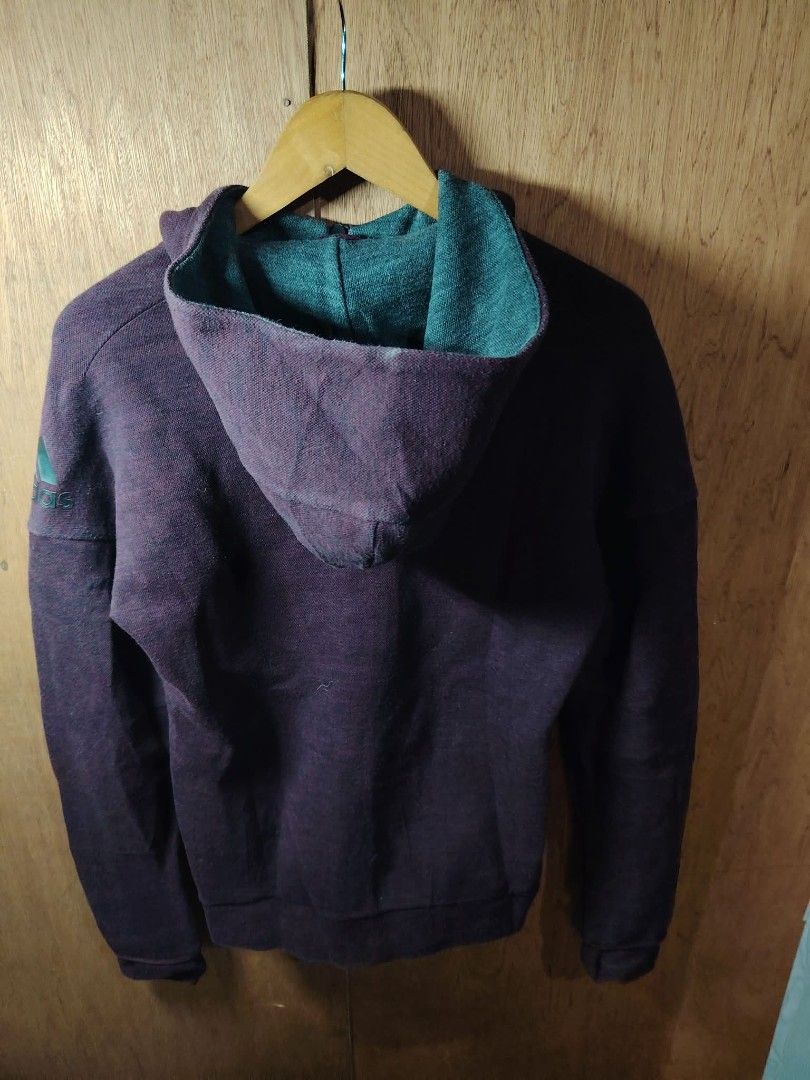 Adidas Maroon Zip Up Hoodie (Category: Coats, Jackets and Outerwear) located in Baguio. Submitted by tabuzomaria1422 (Listing ID 1469701072, Image 2). Description: - Brand: Adidas - Color: Maroon with teal green inner hood - Features: Full zip front, two side pockets, ribbed cuffs and hem - Detail: Signature Adidas logo printed on the right sleeve - Material: Textured fabric - Fit: Regular fit - Condition: Great everyday jacket for cooler weather