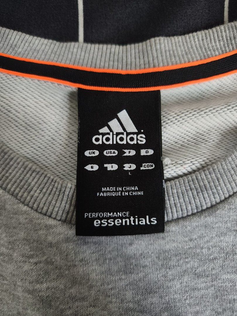 ADIDAS Performance Essentials Gray Sweatshirt Size L (Category: Coats, Jackets and Outerwear) located in Manila. Submitted by gelog2 (Listing ID 1469706890, Image 2). Description: - Brand: Adidas (Performance Essentials Line) - Color: Gray with black sleeve stripes and orange collar piping - Size: L (Length: 27", Width: 22") - Condition: 10/10 (Flawless, like new) - Details: Embroidered Adidas .