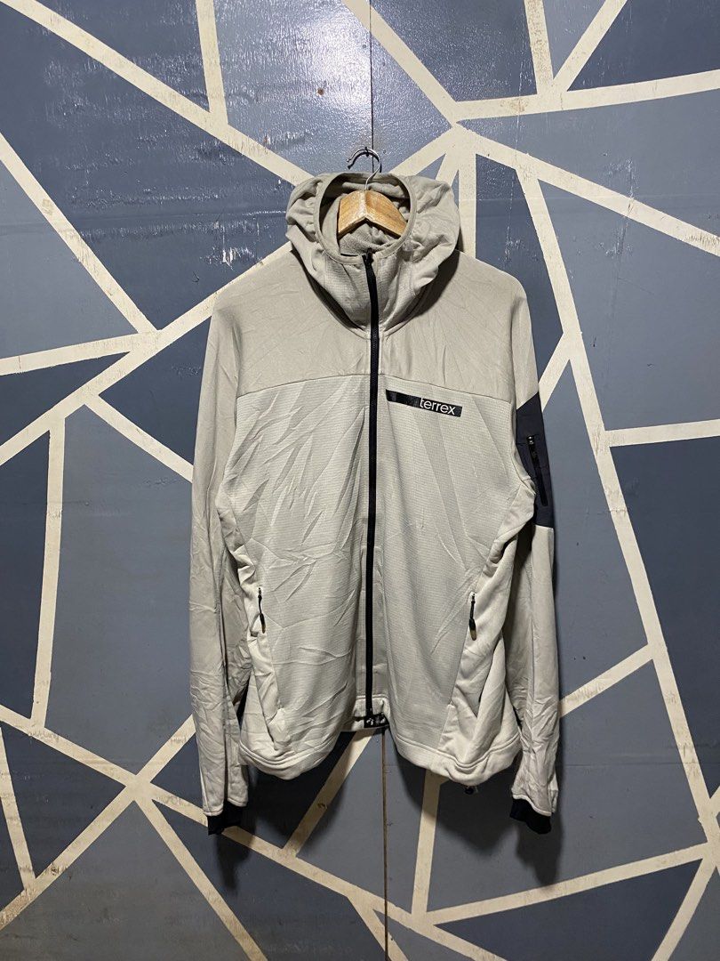 Adidas Terrex Hooded Fleece Jacket Light Grey (Category: Coats, Jackets and Outerwear) located in Polomolok. Submitted by marrssz (Listing ID 1469678745, Image 1). Description: - Brand: Adidas Terrex - Style: Outdoor fleece jacket with hood - Color: Light grey and dark grey contrast panels - Material: Grid fleece interior for warmth and breathability - Pockets: Full zip front, two lower front zip pockets, and one sleeve zip pocket - Extra Feature