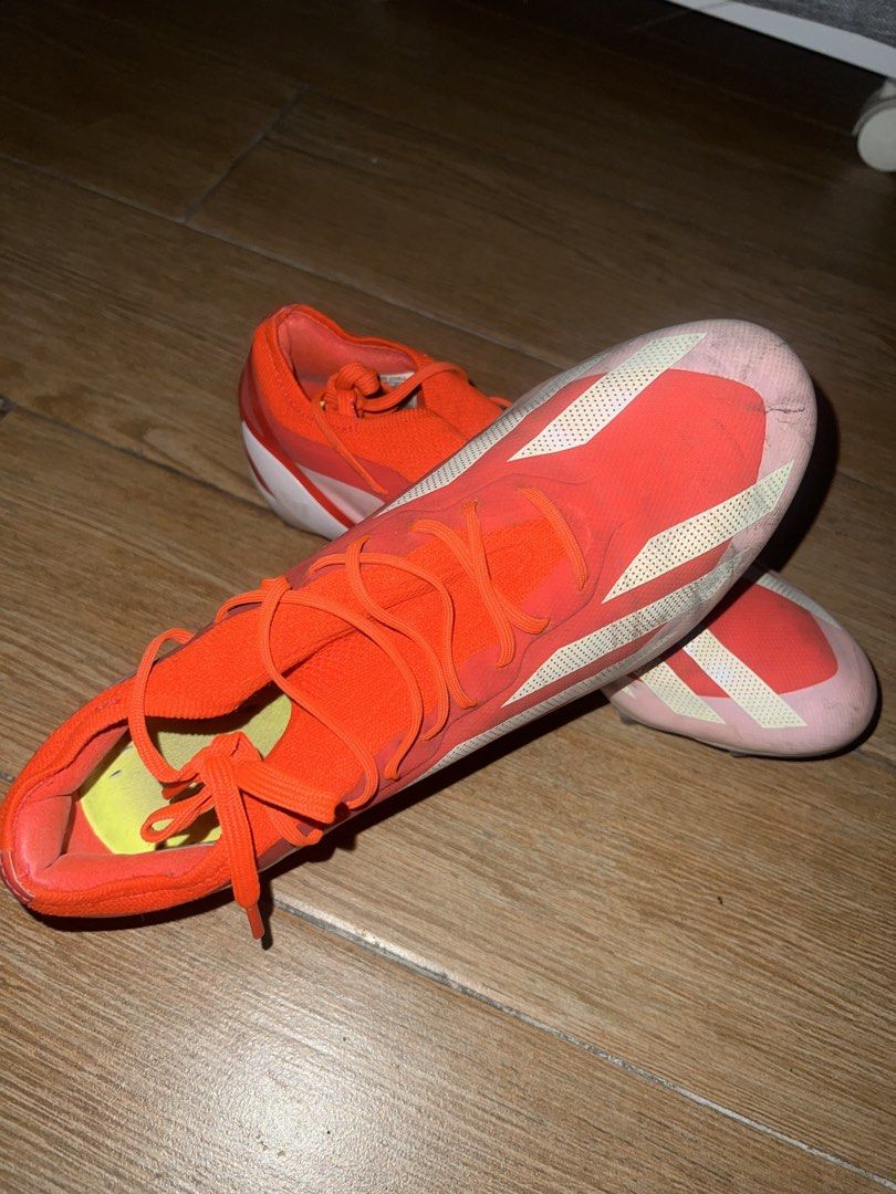 Adidas X Crazyfast Cleats (Category: Racket and Ball Sports) located in Mandaluyong City. Submitted by Shopaholic_Dell (Listing ID 1469653982, Image 1). Description: - Brand: Adidas X Crazyfast - Colorway: Solar orange and white with neon yellow accents and classic three stripes - Traction: Molded studs on the outsole, ideal for firm ground - Upper: Textured synthetic material for enhanced ball control - Closure: Standard lace-up - Condition: Sho