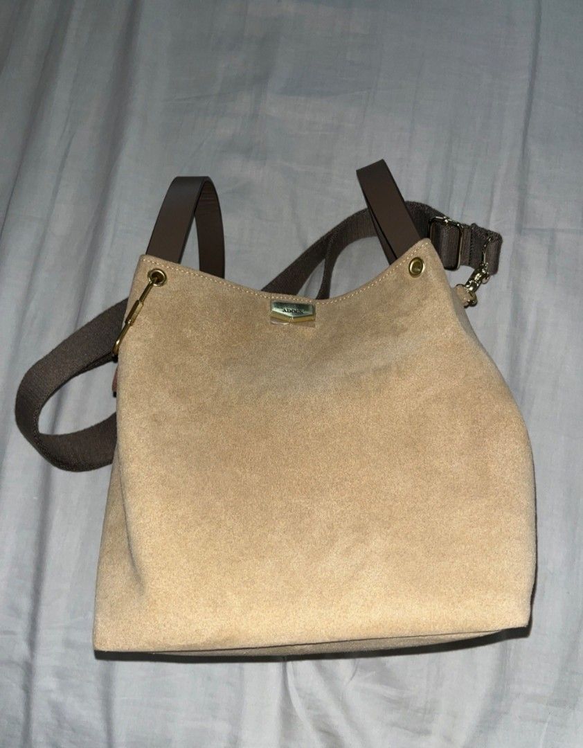Adole Suede Bucket Bag with Brown Straps (Category: Cross-body Bags) located in Cainta. Submitted by chickennuggirl (Listing ID 1469576481, Image 1). Description: - Brand: Adole taiwan brand - Material & Color: Tan suede with dark brown structured top handles - Strap: Includes an adjustable fabric crossbody strap - Hardware: Gold-tone accents with a branded front clasp plate - Interior Organization: nit available - Condition: Excellent / Ready to