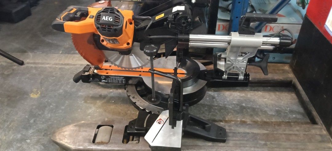 AEG Sliding Miter Saw Power Tool Orange Black (Category: Construction Tools & Equipment) located in Manila. Submitted by jesicahmrsantarosa (Listing ID 1469592920, Image 2). Description: - Brand/Model: AEG Sliding Miter Saw - Color: Orange and Black - Type: Heavy-duty power tool for woodworking and DIY projects - Features: Adjustable angle settings, clear blade guard for safety - Build: Sturdy metal base with slide rails - Condition: Great for wo