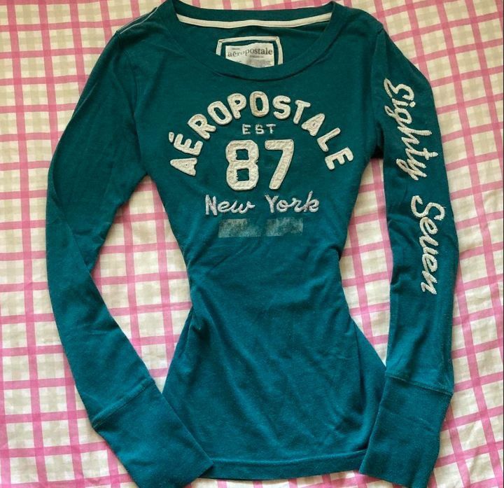 Aeropostale Eighty Seven New York Long Sleeve Tee (Category: Longsleeves) located in Manila. Submitted by y2k_thrift_ (Listing ID 1469714713, Image 1). Description: - Brand: Aeropostale - Color: Teal Green - Size: L/G - Material: 60% Cotton, 40% Polyester - Design: Big embroidered chest logo with '87 New York' lettering and 'Eighty Seven' down the left sleeve - Details: Crew neck style with ribbed cuffs - Origin: Made in Indonesia.