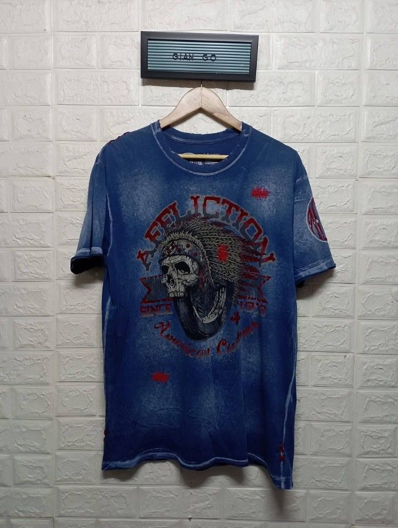 Affliction Live Fast Born Fast Skull T-Shirt (Category: Tshirts & Polo Shirts ) located in Taguig. Submitted by giango1313 (Listing ID 1469584991, Image 2). Description: - Brand: Affliction - Design: Detailed skull and headdress with bold red lettering (front and back prints) - Wash/Finish: Dark acid wash with heavy distressing - Material: Heavyweight cotton for durability and character - Fit: Standard fit, true to size - Style: Casual streetwear