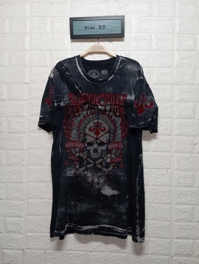 Affliction Live Fast Born Fast Skull T-Shirt (Category: Tshirts & Polo Shirts ) located in Taguig. Submitted by giango1313 (Listing ID 1469584991, Image 1). Description: - Brand: Affliction - Design: Detailed skull and headdress with bold red lettering (front and back prints) - Wash/Finish: Dark acid wash with heavy distressing - Material: Heavyweight cotton for durability and character - Fit: Standard fit, true to size - Style: Casual streetwear