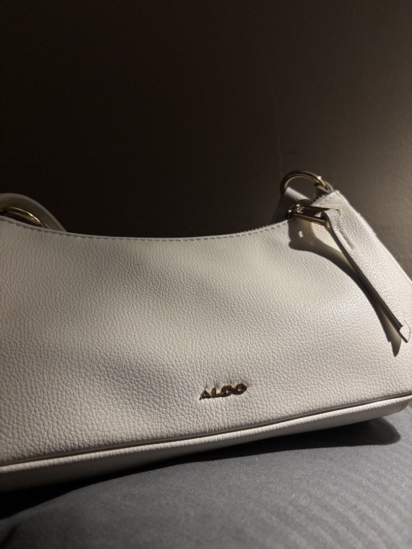 Aldo White Bag (Category: Shoulder Bags) located in Manila. Submitted by luckiachai (Listing ID 1469688698, Image 2). Description: Elegant and stylish ALDO white shoulder bag featuring a beautiful textured finish, luxurious gold-tone hardware, and a charming front flap pocket. It comes with a top zipper closure, a detachable-looking gold key charm, and an adjustable strap for a chic and versatile look. Perfect for casual outings, dates, parties, 