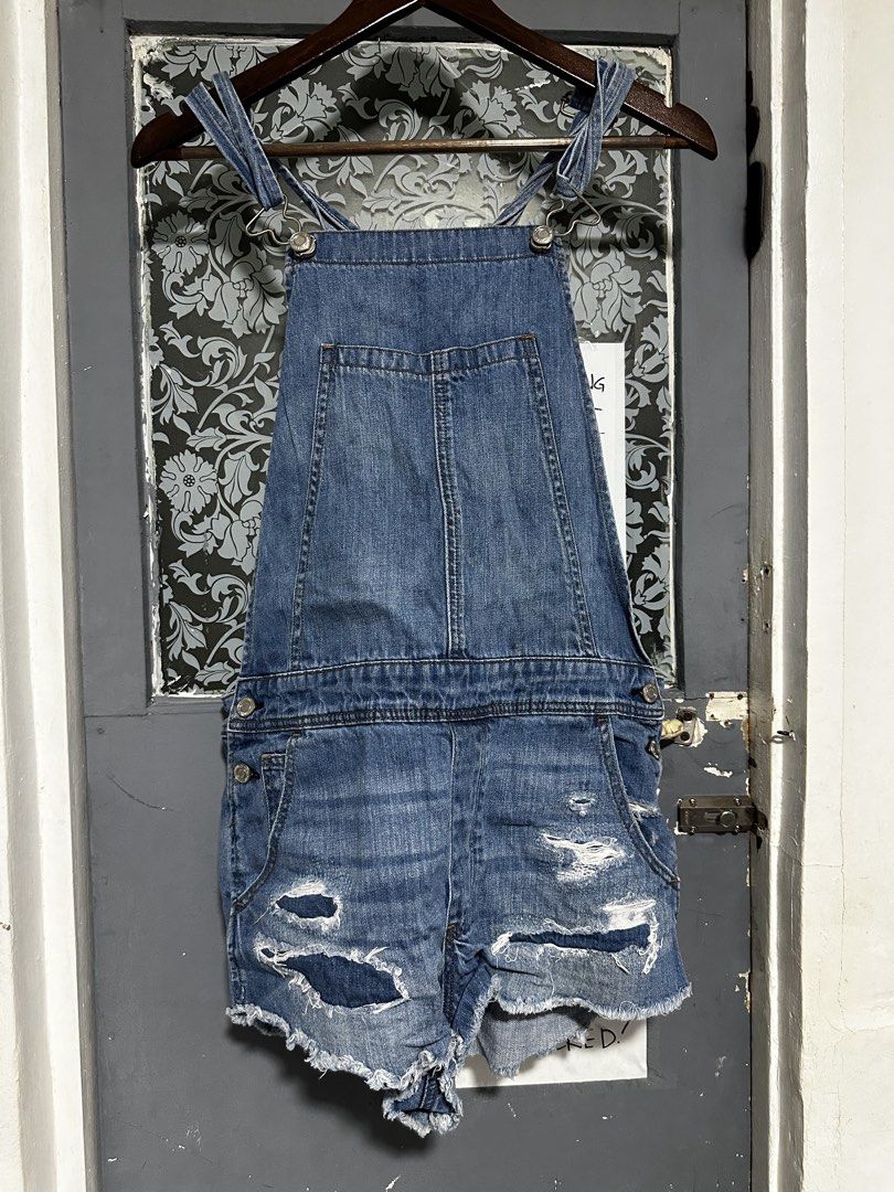 American Eagle Outfitters Distressed Denim Short Overalls (Category: Rompers) located in Quezon City. Submitted by breakstuf50 (Listing ID 1469735646, Image 1). Description: - Brand: American Eagle Outfitters (AEO) - Style: Denim overall shorts / Romper - Wash: Medium blue with trendy factory distressing, rips, and raw hems - Features: Adjustable shoulder straps with metal hardware, branded side buttons, front bib pocket, and back pockets - Condi
