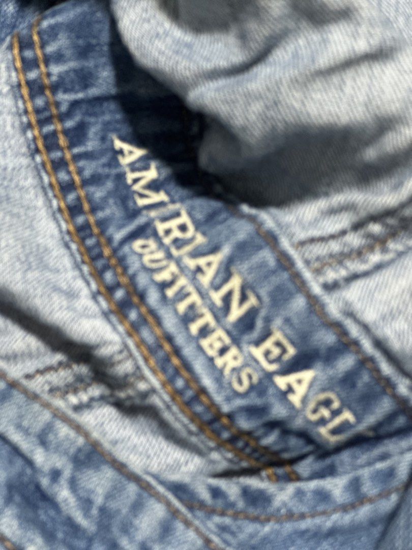 American Eagle Outfitters Distressed Denim Short Overalls (Category: Rompers) located in Quezon City. Submitted by breakstuf50 (Listing ID 1469735646, Image 2). Description: - Brand: American Eagle Outfitters (AEO) - Style: Denim overall shorts / Romper - Wash: Medium blue with trendy factory distressing, rips, and raw hems - Features: Adjustable shoulder straps with metal hardware, branded side buttons, front bib pocket, and back pockets - Condi