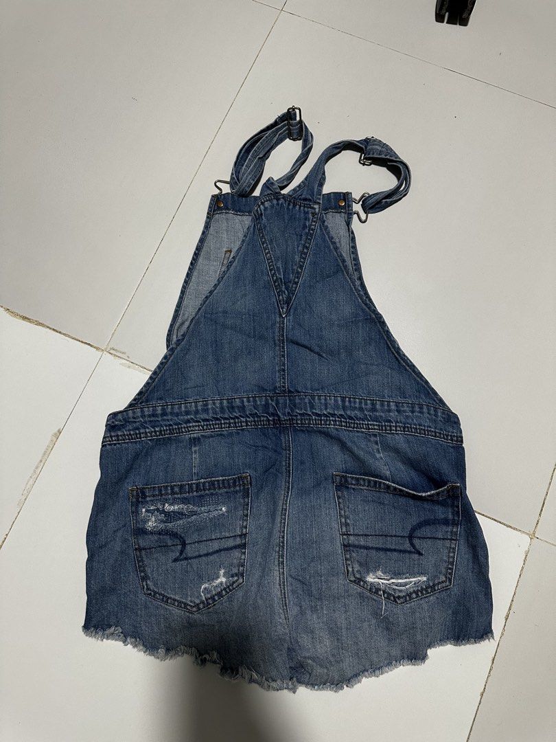 American Eagle Outfitters Distressed Denim Short Overalls (Category: Rompers) located in Quezon City. Submitted by breakstuf50 (Listing ID 1469735646, Image 3). Description: - Brand: American Eagle Outfitters (AEO) - Style: Denim overall shorts / Romper - Wash: Medium blue with trendy factory distressing, rips, and raw hems - Features: Adjustable shoulder straps with metal hardware, branded side buttons, front bib pocket, and back pockets - Condi