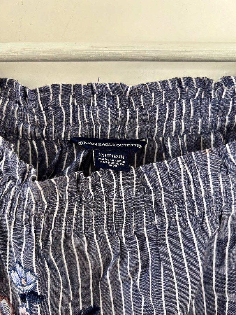 American Eagle Striped Embroidered Off-The-Shoulder Blouse (Category: Blouses) located in Manila. Submitted by isabelle_1104 (Listing ID 1469644992, Image 2). Description: Blue and white striped off-the-shoulder top from American Eagle Outfitters. Size XS. Pretty floral embroidery details scattered on the front and sleeves. Long sleeves with tie cuffs. Elastic neckline. Lightweight material, great for warm weather. Clean and well maintained..