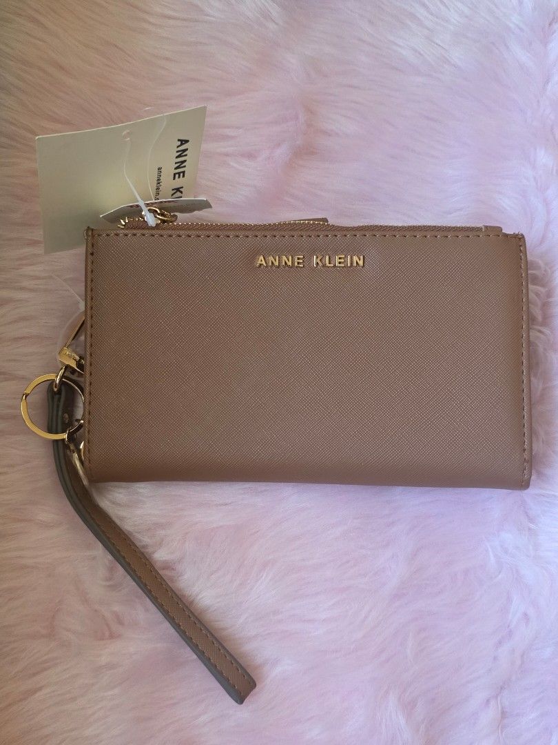 Anne Klein Brown Wristlet Wallet with Tags (Category: Wallets & Card holders) located in Amadeo. Submitted by riccchfinds (Listing ID 1469649905, Image 1). Description: - Brand: Anne Klein - Color: Brown - Material: Textured Saffiano finish with gold-tone hardware - Features: Detachable wrist strap, exterior zip pocket, multiple card slots, and ID window - Closure: Secure snap button - Condition: Brand new with original store tags attached.