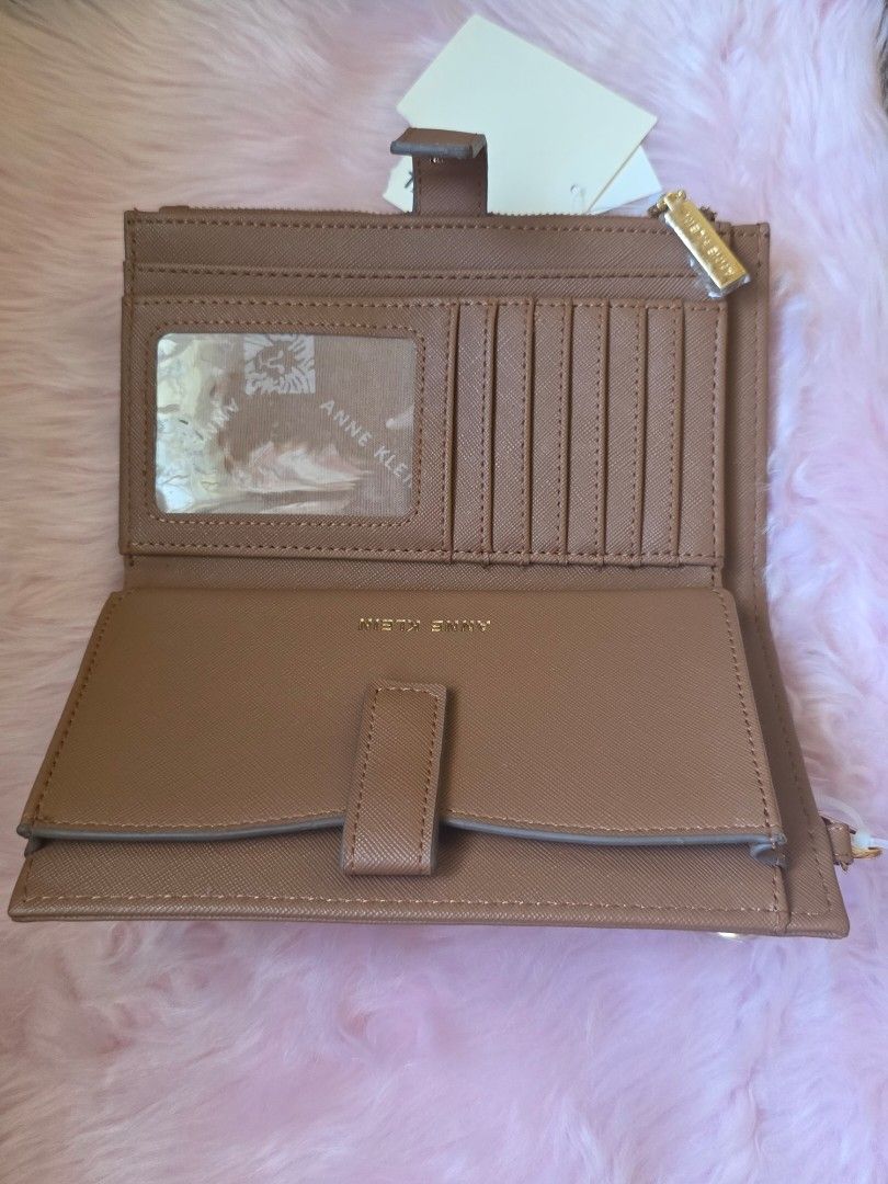 Anne Klein Brown Wristlet Wallet with Tags (Category: Wallets & Card holders) located in Amadeo. Submitted by riccchfinds (Listing ID 1469649905, Image 3). Description: - Brand: Anne Klein - Color: Brown - Material: Textured Saffiano finish with gold-tone hardware - Features: Detachable wrist strap, exterior zip pocket, multiple card slots, and ID window - Closure: Secure snap button - Condition: Brand new with original store tags attached.
