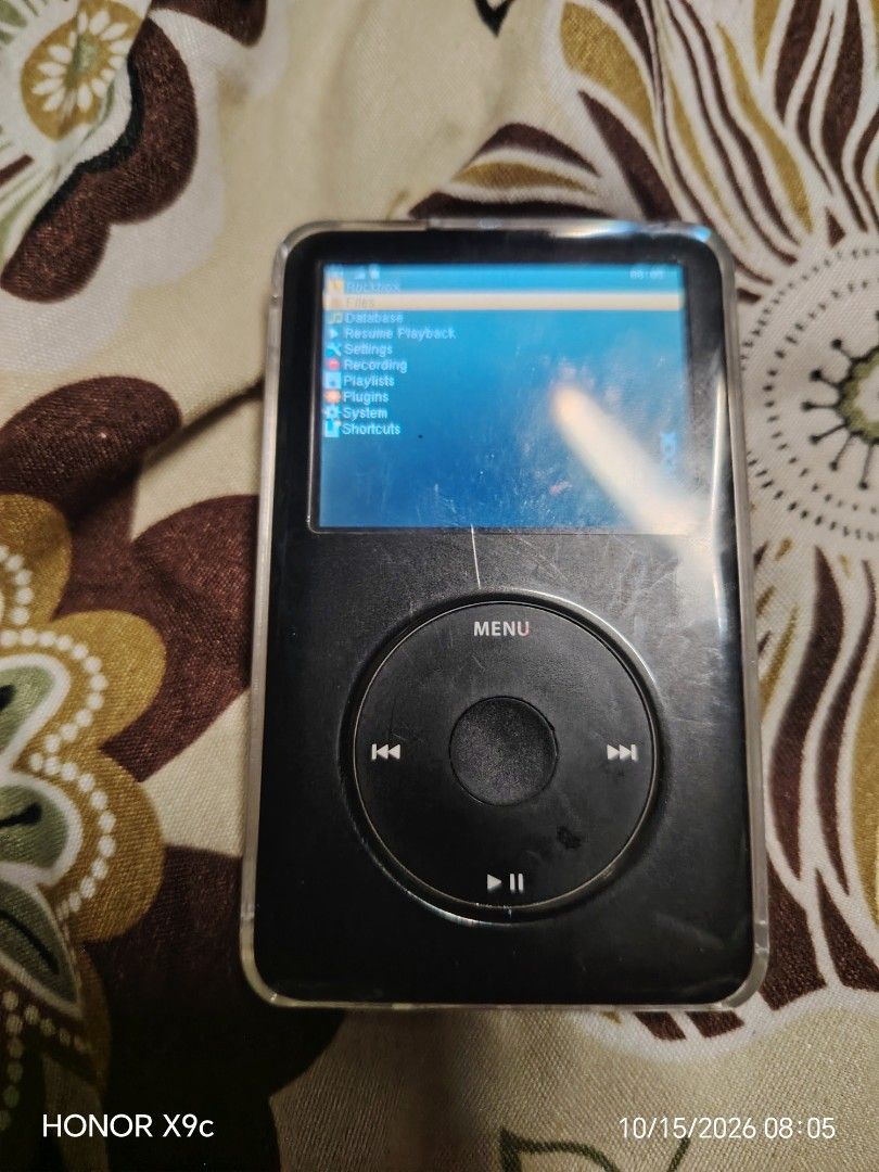 Apple iPod Classic with Rockbox Firmware (Category: Portable Music Players) located in Manila. Submitted by flashghie (Listing ID 1469737746, Image 1). Description: - Classic Black Apple iPod Classic with Rockbox firmware installed - Monochrome click wheel interface for smooth navigation - Stylish carbon fiber texture skin on the back metal casing - Includes a clear plastic protective case - Standard 30-pin dock connector and headphone jack - Phy