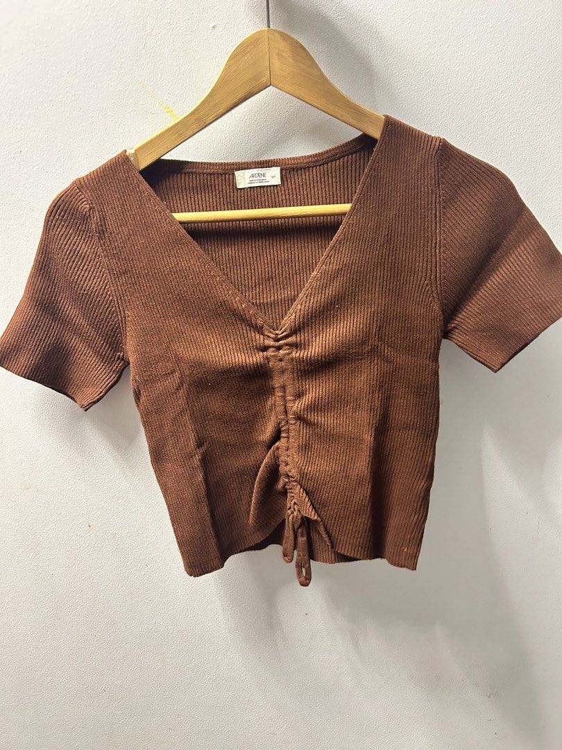 Ardene Brown Top (Category: Blouses) located in Antipolo. Submitted by tshopph (Listing ID 1469711523, Image 2). Description: Super cute and flattering brown ribbed knit short-sleeve top. Features a deep V-neckline with an adjustable front cinched/drawstring detail so you can adjust the crop level and gather to your liking. Made from a stretchy, comfortable ribbed fabric. Perfect for casual wear, daily layering, or pairing with high-waisted jeans